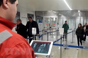 Nhân viên chữ thập đỏ dùng máy quét thân nhiệt để kiểm tra thân nhiệt hành khách tại sân bay Fiumicino, Rome, Italy, ngày 5/2/2020. (Ảnh: AFP/ TTXVN).