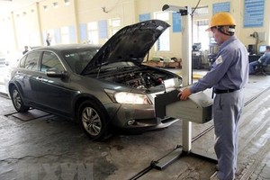 Đăng kiểm viên tiến hành kiểm định phương tiện đến đăng kiểm. (Ảnh: Hoàng Hùng/TTXVN).