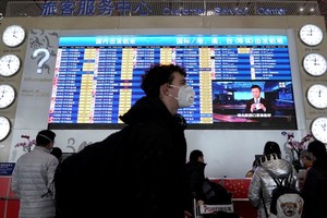 Hành khách đeo khẩu trang tại sân bay Bắc Kinh. (Ảnh: Reuters).