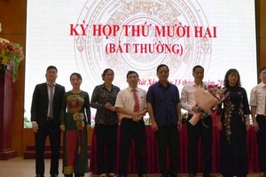 Ông Nguyễn Trung Triều (áo trắng) nhận hoa chúc mừng.