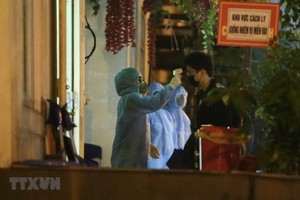 Nhân viên y tế sẽ đo thân nhiệt cho mỗi người trước khi vào khu cách ly. (Ảnh: Minh Quyết/TTXVN).