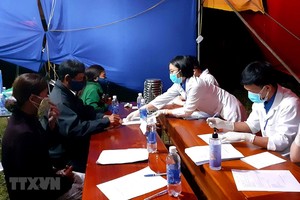 Sinh viên tình nguyện hướng dẫn người dân khai báo y tế tại chốt kiểm soát y tế thị xã Hương Trà. (Ảnh: Tường Vi/TTXVN).