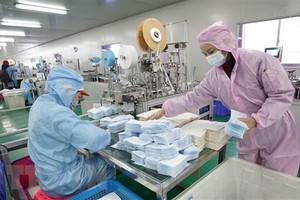 Công nhân nỗ lực may khẩu trang y tế tại một nhà máy ở Vũ Hán, Trung Quốc. (Ảnh: THX/TTXVN).