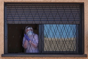 Một thành viên của Đơn vị khẩn cấp đang khử trùng vùng ngoại ô Getafe của Madrid vào ngày 25/3. Ảnh: AFP.