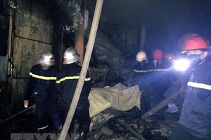 Lực lượng chức năng đã tiếp cận được nạn nhân trong vụ cháy. (Ảnh: Công Tường/TTXVN).