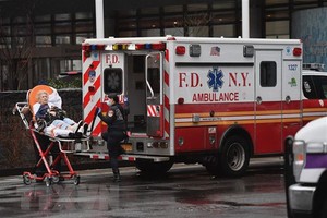 Nhân viên y tế chuyển bệnh nhân nghi nhiễm COVID-19 tới bệnh viện ở New York, Mỹ, ngày 23/3/2020. (Nguồn: AFP/TTXVN).