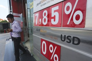 Việc các ngân hàng hạ mặt bằng lãi suất huy động cả kỳ hạn ngắn và dài góp phần làm giảm mức hấp dẫn của việc nắm giữ VND.