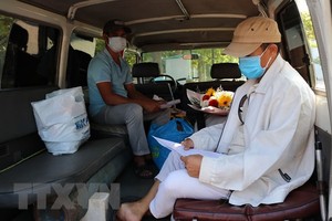 Bệnh nhân nhận và kiểm tra giấy chứng nhận ra viện. (Ảnh: Nguyễn Thành/TTXVN).