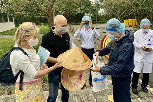 Lãnh đạo Sở Du lịch tỉnh Thừa Thiên-Huế tặng nón lá lưu niệm cho nữ bệnh nhân số 30. (Ảnh: Mai Trang/TTXVN).