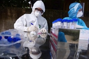 Nhân viên y tế lấy mẫu xét nghiệm nCoV cho người dân Hạ Lôi.