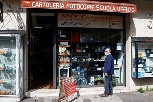 Người dân đứng trước một cửa hàng ở thành phố Catania, Italy hôm nay, sau khi chính phủ cho phép một số nơi mở cửa lại. Ảnh: Reuters.