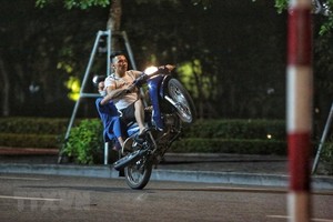 Các thanh niên bốc đầu, đua xe quanh hồ Gươm. (Ảnh: TTXVN).