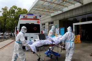 Nhân viên y tế chuyển bệnh nhân nhiễm COVID-19 tới bệnh viện ở Vũ Hán, tỉnh Hồ Bắc, Trung Quốc, ngày 11/4/2020. (Ảnh: THX/TTXVN).