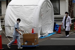 Nhân viên y tế bước qua một chiếc lều dùng để xét nghiệm nCoV tại bệnh viện đa khoa Kawakita ở Tokyo, Nhật Bản, ngày 17/4. Ảnh: Reuters.