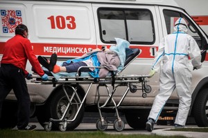 Nhân viên y tế chuyển bệnh nhân tới bệnh viện ở ngoại ô Moscow. (Ảnh: AFP).