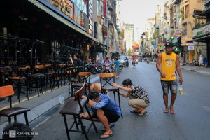 Nhân viên một quán bar ở phố Tây Bùi Viện, quận 1 sơn sửa lại bàn ghế để chuẩn bị mở cửa trở lại từ hôm 23/4, ngay sau khi hết lệnh cách ly theo Chỉ thị 16 của Thủ tướng.