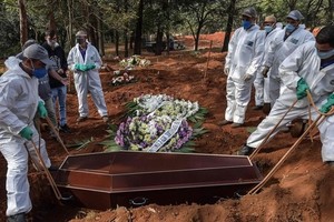 Công nhân mặc đồ bảo hộ chôn cất nạn nhân Covid-19 tại một nghĩa trang ở ngoại ô Sao Paulo, Brazil hôm 20/5. Ảnh: AFP.