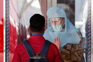 Nhân viên an ninh nói chuyện với hành khách tại sân bay ở New Delhi, Ấn Độ ngày 25/5. Ảnh: Reuters.