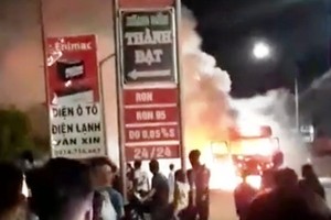 Xe tải cháy ngùn ngụt gần đường điện, cây xăng dầu nên người dân phải đẩy xe ra xa khu vực có thể gây nguy hiểm.