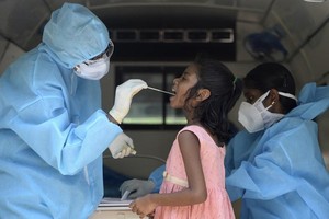 Nhân viên y tế lấy mẫu xét nghiệm nCoV cho một bé gái tại thành phố Chennai, Ấn Độ, hôm 16/6. Ảnh: AFP.