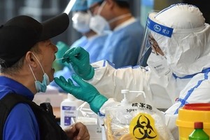 Nhân viên y tế lấy mẫu xét nghiệm nCoV cho một người dân ở thành phố Nam Kinh, tỉnh Giang Tô, Trung Quốc, ngày 15/6. Ảnh: AFP.