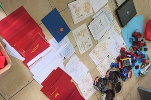 Nhiều tang vật giấy tờ làm giả.