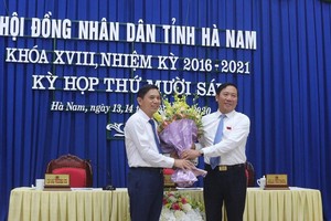 Ông Phạm Sỹ Lợi, Phó Bí thư thường trực Tỉnh ủy, Chủ tịch HĐND tỉnh Hà Nam tặng hoa chúc mừng ông Trần Xuân Dưỡng.