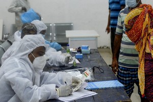 Nhân viên y tế và người dân tại một điểm sàng lọc y tế ở Mumbai, Ấn Độ, hôm 27/7. Ảnh: AFP.