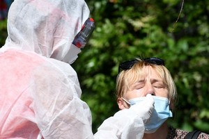 Nhân viên y tế lấy mẫu xét nghiệm Covid-19 cho một phụ nữ ở Zagreb, Croatia, hôm 17/8. Ảnh: AFP.