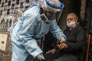 Nhân viên Bộ Y tế Peru kiểm tra và xét nghiệm Covid-19 cho một phụ nữ ở thủ đô Lima hôm 20/8. Ảnh: AFP.