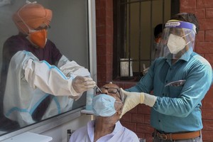 Nhân viên y tế lấy mẫu xét nghiệm từ người dân ở thành phố Amritsar, Ấn Độ, hôm 24/8. Ảnh: AFP.