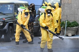 Nhân viên khử trùng khu vực phía trước một bệnh viện ở Hungary ngày 27/8. Ảnh: AFP.