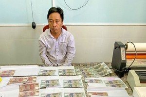 Đối tượng Trần Văn Tâm cùng tang vật. (Ảnh: TTXVN phát).