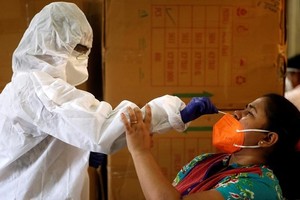 Nhân viên y tế lấy mẫu xét nghiệm cho một người dân ở Mumbai, Ấn Độ, ngày 7/9. Ảnh: Reuters.