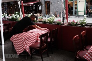 Nhân viên sửa soạn lại bàn ghế tại một nhà hàng ở New York, Mỹ. (Ảnh: AFP/TTXVN).