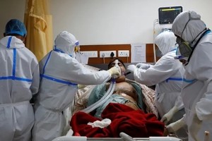 Nhân viên y tế chăm sóc cho một bệnh nhân nhiễm nCoV tại bệnh viện ở ngoại ô thủ đô New Delhi, Ấn Độ, ngày 15/9. Ảnh: Reuters.