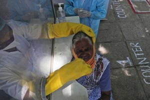 Nhân viên y tế lấy mẫu xét nghiệm cho người dân ở Hyderabad, Ấn Độ, hôm 3/10. Ảnh: AP.