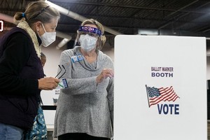 Tình nguyện viên hướng dẫn cử tri tại điểm bỏ phiếu sớm tại Ohio ngày 6/10. Ảnh: AFP.