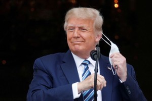 Ông Trump tháo khẩu trang khi phát biểu trước hàng trăm người. (Ảnh: Reuters).