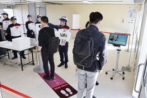 Công tác an ninh sẽ được siết chặt với đội ngũ bảo vệ được trang bị mặt nạ và thiết bị đo thân nhiệt. Nguồn: Kyodo. 