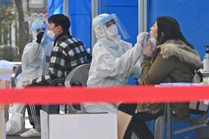 Nhân viên y tế lấy mẫu xét nghiệm COVID-19 cho người dân tại Seoul, Hàn Quốc ngày 27/11/2020. (Ảnh: AFP/TTXVN).