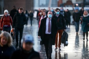 Người dân Anh đi bộ qua cầu London ngày 15-12 trong khi virus SARS-CoV-2 vẫn đang lây lan nhanh chóng. Ảnh: Reuters.