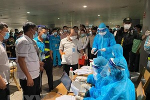 Nhân viên y tế làm thủ tục lấy mẫu xét nghiệm cho người làm việc tại sân bay Tân Sơn Nhất, ngày 6/2. (Ảnh: TTXVN phát).