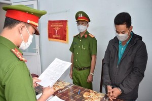 Cơ quan CSĐT Công an tỉnh Quảng Nam tống đạt các quyết định khởi tố và bắt tạm giam Nguyễn Duy Hoàng. (Ảnh: Công an tỉnh Quảng Nam).