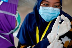 Các nhân viên y tế được tiêm ngừa COVID-19 tại Jakarta, Indonesia, ngày 27-1.( Ảnh: REUTERS).