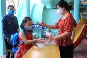 Đo thân nhiệt, rửa tay cho trẻ trước khi vào lớp. (Ảnh minh họa: Lê Thúy Hằng/TTXVN).