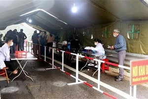 Chốt kiểm soát dịch COVID-19 tại chân cầu Bạch Đằng vẫn thực hiện khai báo đồng thời hai hình thức thủ công và điện tử. (Ảnh: Văn Đức/TTXVN).