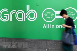 Biểu tượng hãng gọi xe công nghệ Grab tại văn phòng ở Singapore. (Ảnh: AFP/TTXVN).