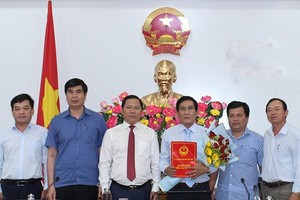 Ông Nguyễn Phi Long- Chủ tịch UBND tỉnh Bình Định (áo trắng đứng giữa) trao quyết định cho ông Trần Thanh Dũng.