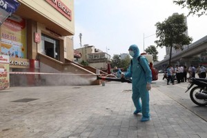 Lực lượng y tế phun khử khuẩn nơi ở một trường hợp F0. (Ảnh: Thành Đạt/TTXVN).